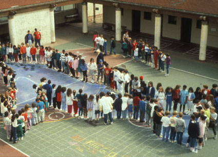 Students standing along the outside of a life-sized whale drawing